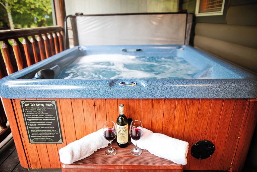 Pigeon Hills hot tub on deck with wine glasses towels and mountain forest views