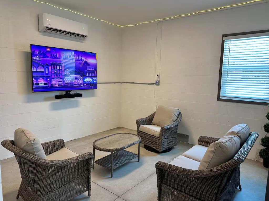 Seaside Boca lounge area with TV and wicker seating in game room